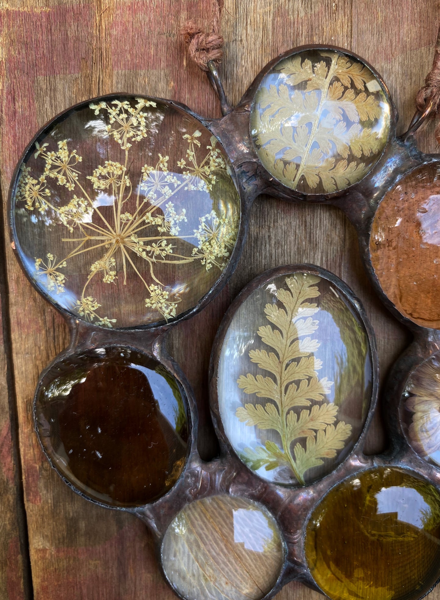 Decorative items with pressed flowers and leaves on a wooden surface glass art