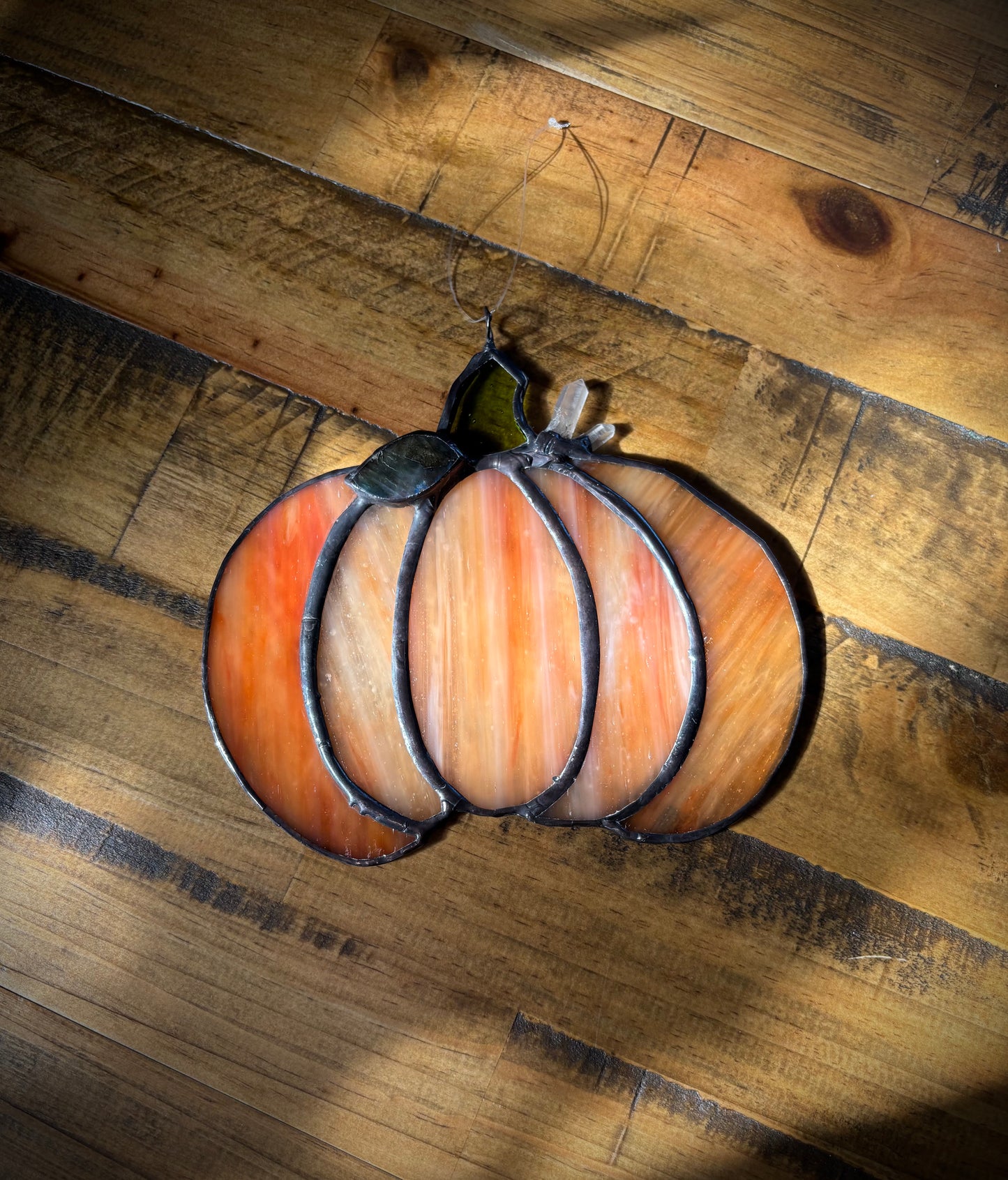 Decorative glass pumpkin on a wooden surface.