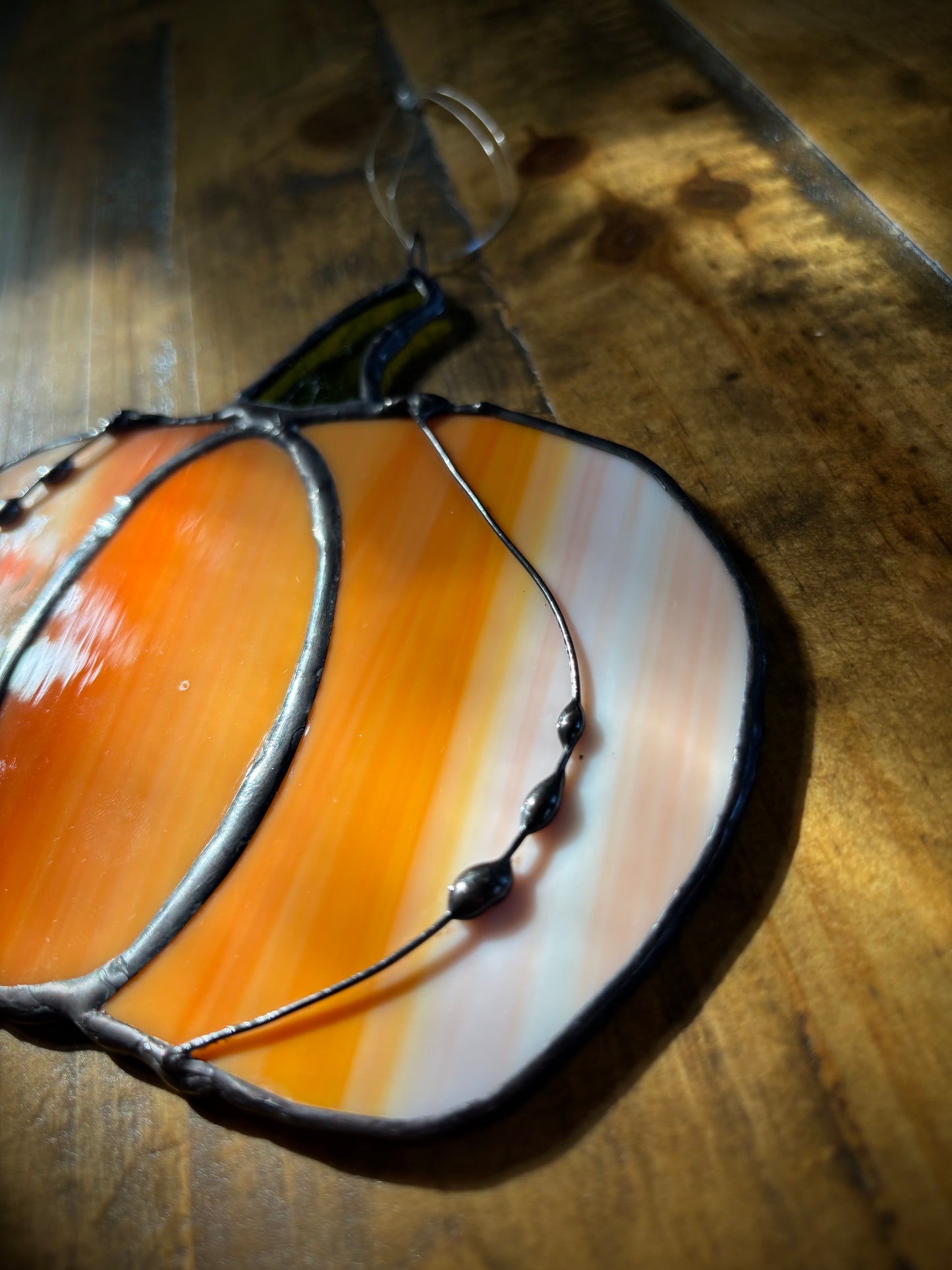 Decorative glass pumpkin on a wooden surface.